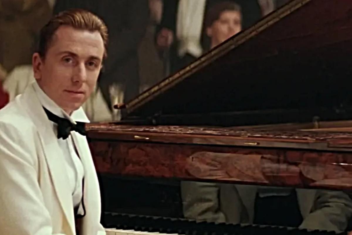 Tim Roth seduto al piano